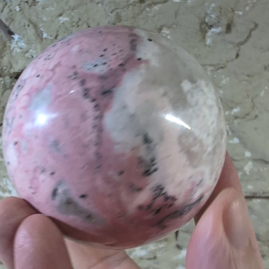 Video of polished pink rhodonite sphere showing color transitions