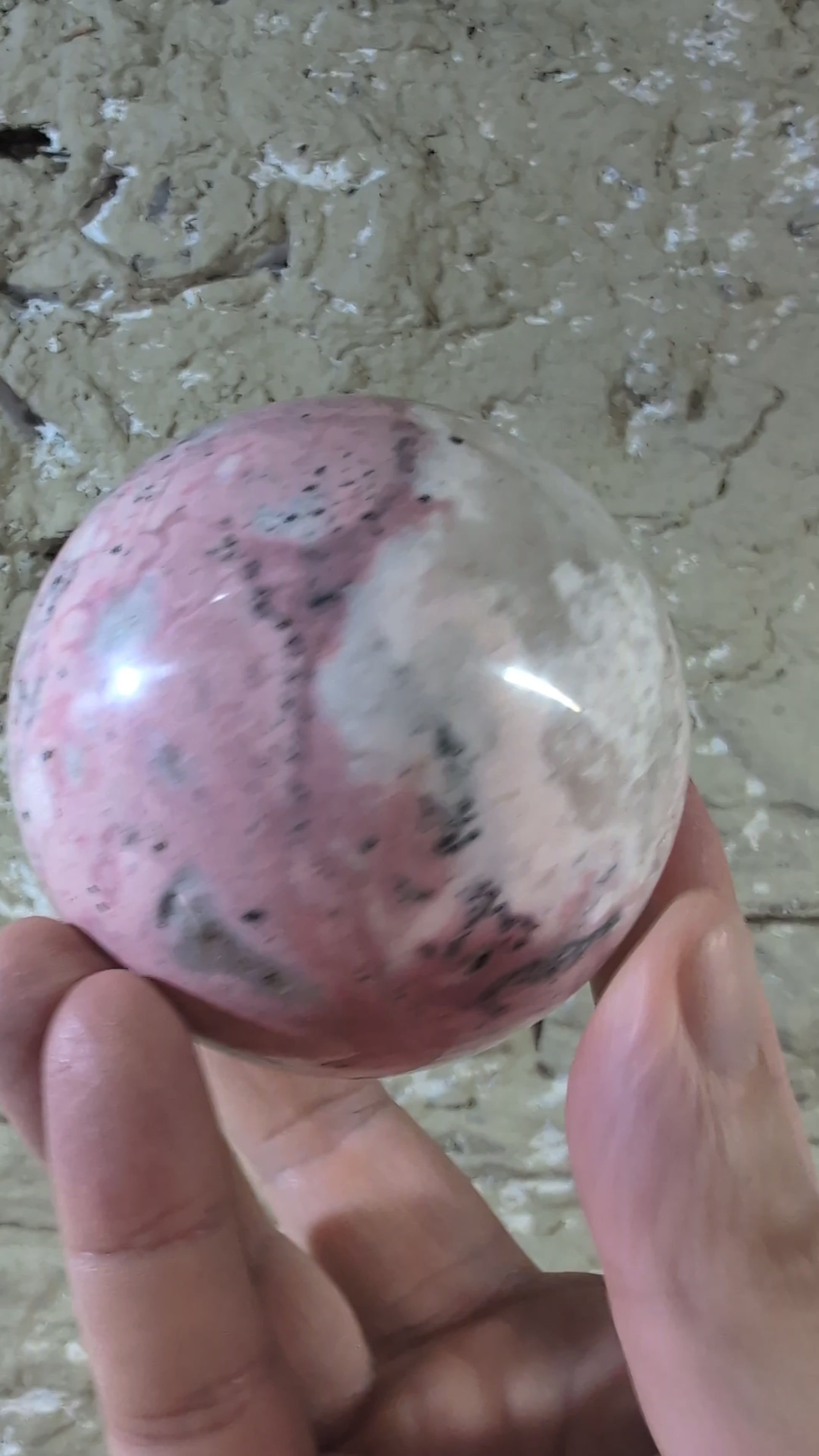 Video of polished pink rhodonite sphere showing color transitions