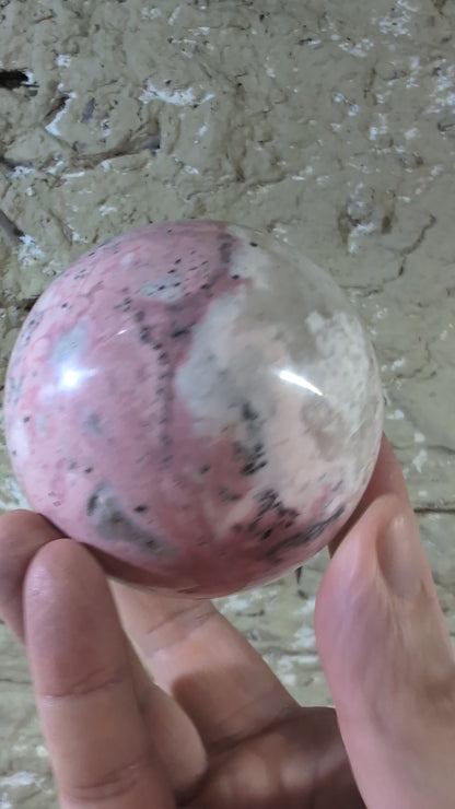 Video of polished pink rhodonite sphere showing color transitions