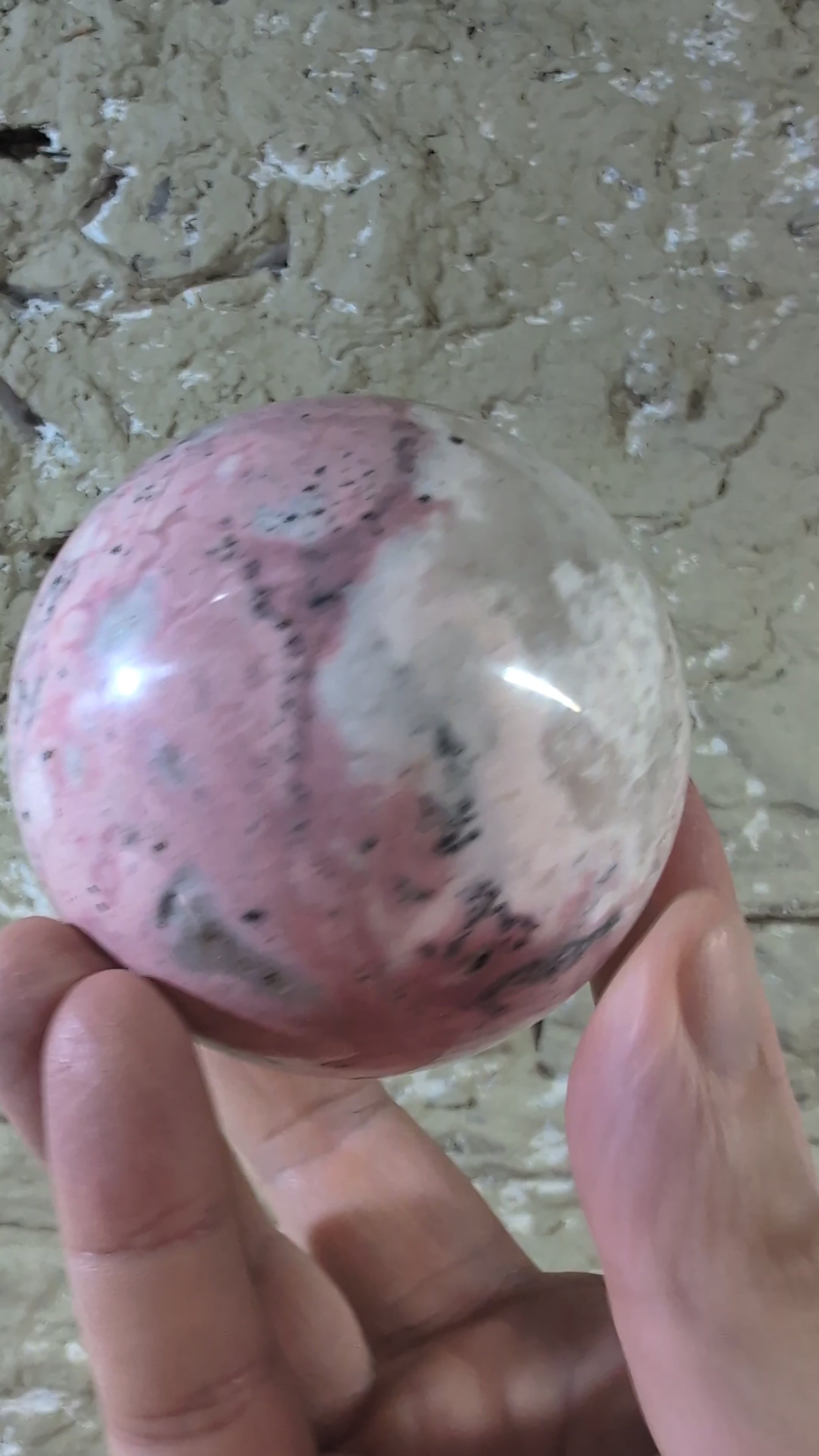 Video of polished pink rhodonite sphere showing color transitions