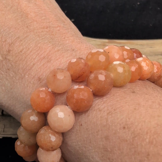 Video showcasing two 8mm faceted Red Aventurine stretch bracelets worn stacked on a wrist, catching the light to highlight the geometric cuts and natural sparkle.