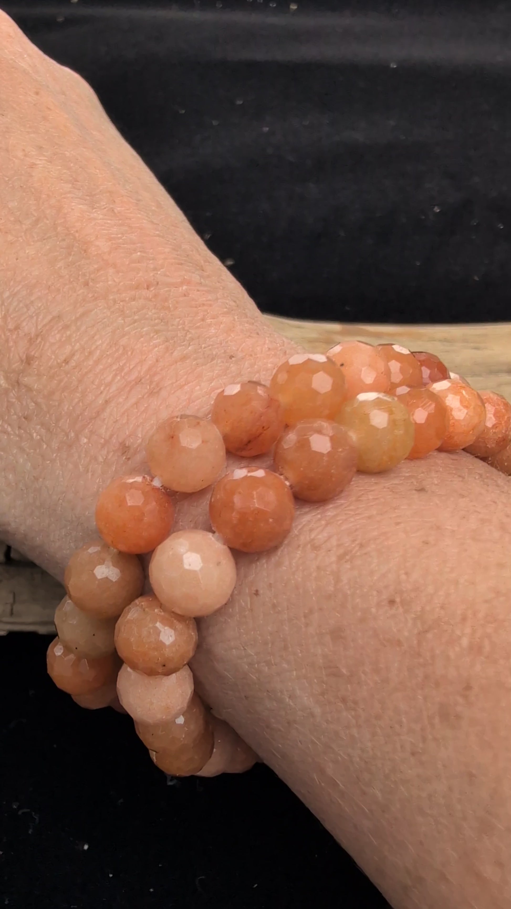 Video showcasing two 8mm faceted Red Aventurine stretch bracelets worn stacked on a wrist, catching the light to highlight the geometric cuts and natural sparkle.