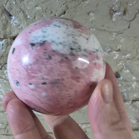 Video of pink rhodonite sphere with natural pattern variations