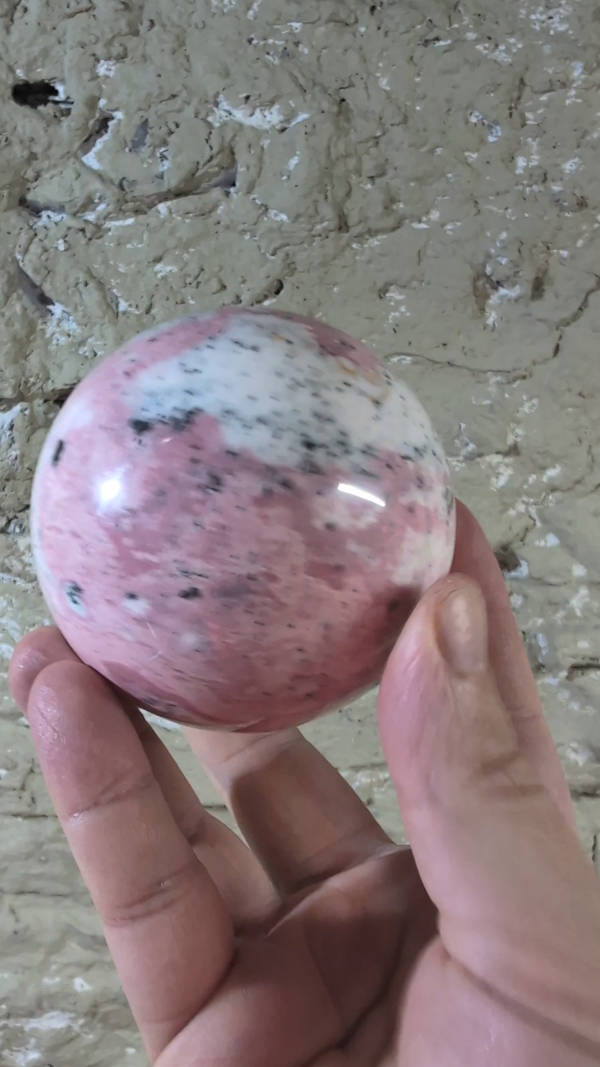Video of pink rhodonite sphere with natural pattern variations