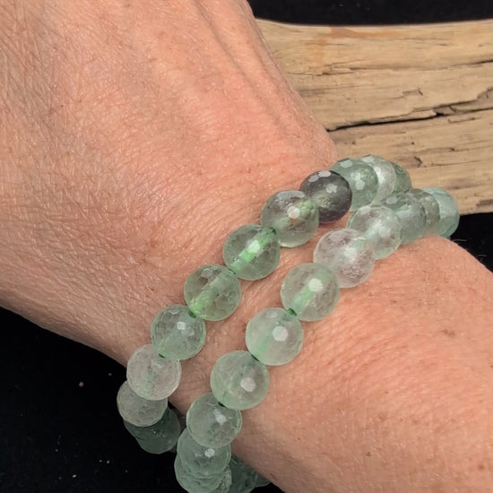 Video showcasing the highly reflective faceted texture, glassy lustre, and internal cleavage of both the green and mixed purple/green 8mm Fluorite beaded stretch bracelets worn on a wrist.