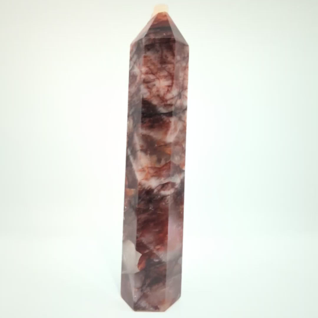 Video showcasing multiple Brazilian Fire Quartz towers in various sizes. Polished hematoid quartz points with fiery red hematite inclusions rotating under natural light.