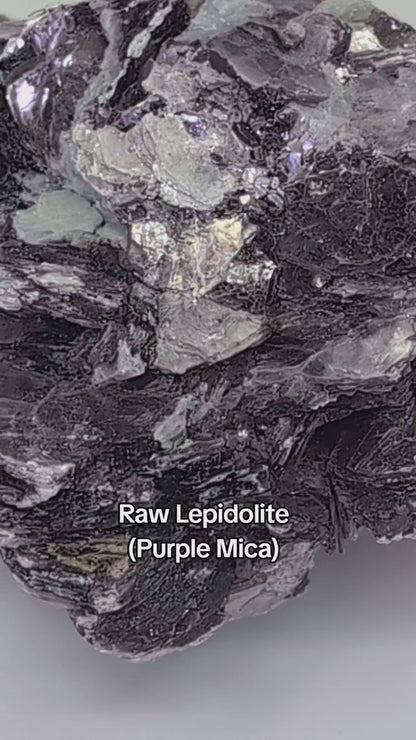 Raw purple Lepidolite mica book showcasing natural platy structure and shimmering luster.