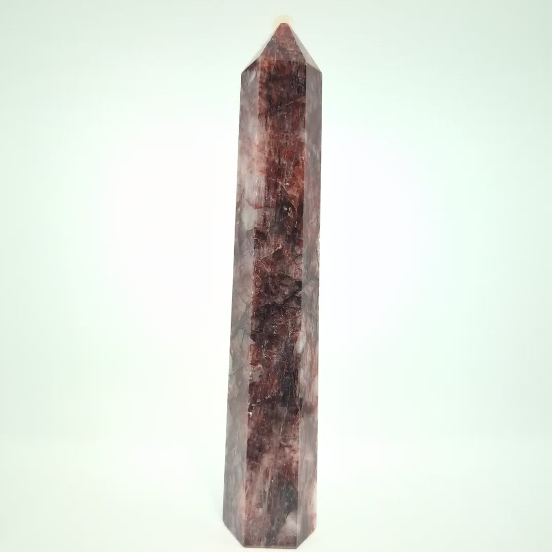 Video showcasing multiple Brazilian Fire Quartz towers in various sizes. Polished hematoid quartz points with fiery red hematite inclusions rotating under natural light.