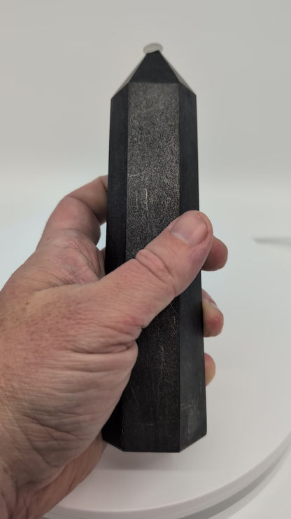 360° rotation video of large 500g polished Shungite tower showing deep matte-black sheen and geometric cut from Karelia, Russia.