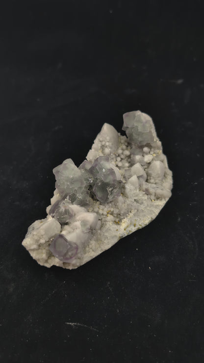 360-degree video of green window fluorite specimen on milky quartz, showing cubic zoning, surface brilliance, and UV fluorescence reaction