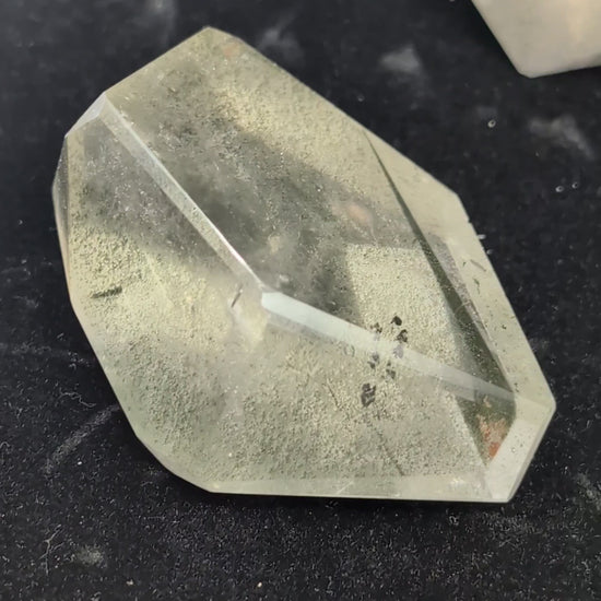 Video showcasing a collection of polished medium Garden Quartz faceted freeforms, highlighting their clarity and dense green and red internal mineral inclusions.