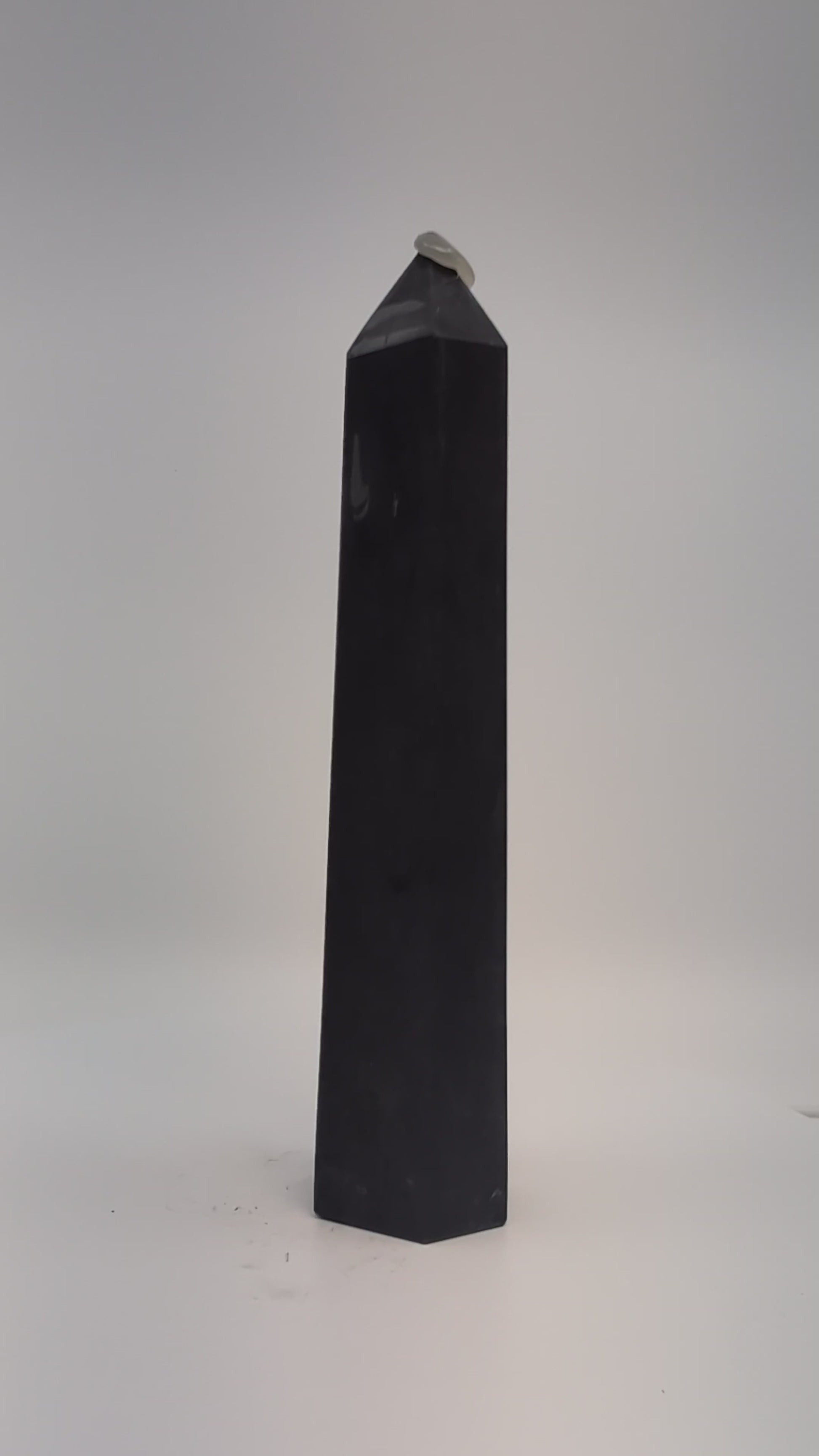 Rotating clip of 360g Shungite tower emphasizing smooth polish, dark luster, and base details.