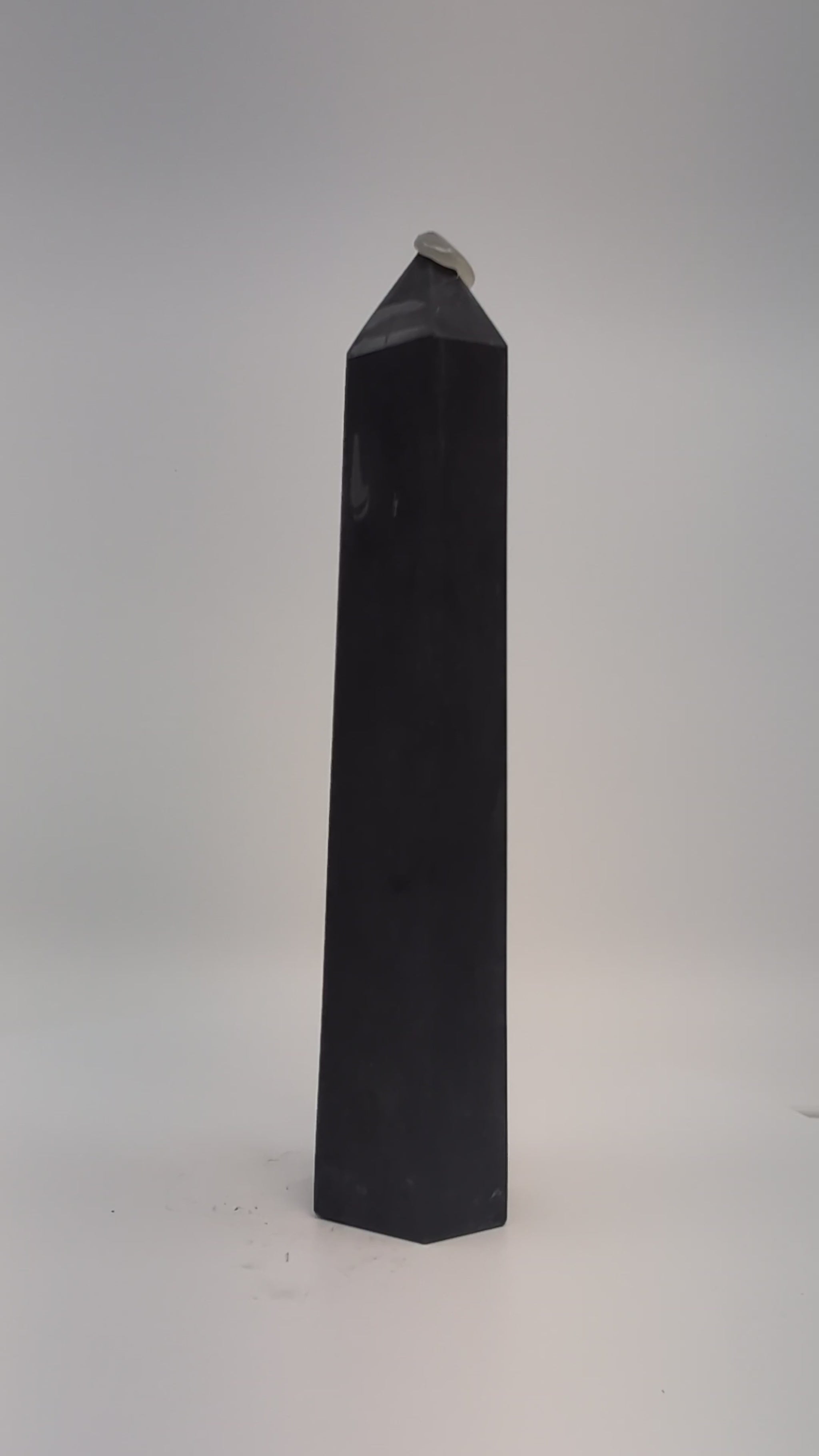 Rotating clip of 360g Shungite tower emphasizing smooth polish, dark luster, and base details.