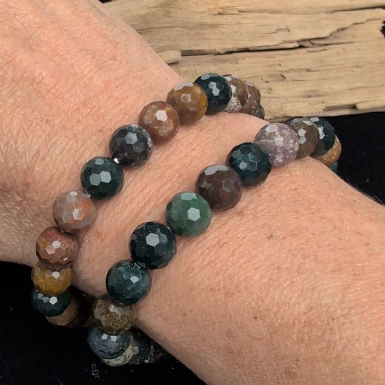 Video showcasing the highly reflective faceted texture and vibrant, multi-coloured orbicular patterns of an 8mm Ocean Jasper beaded stretch bracelet worn on a wrist.