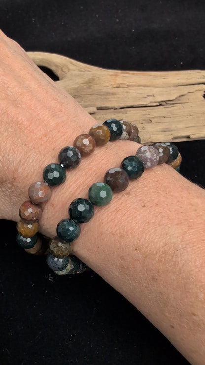 Video showcasing the highly reflective faceted texture and vibrant, multi-coloured orbicular patterns of an 8mm Ocean Jasper beaded stretch bracelet worn on a wrist.