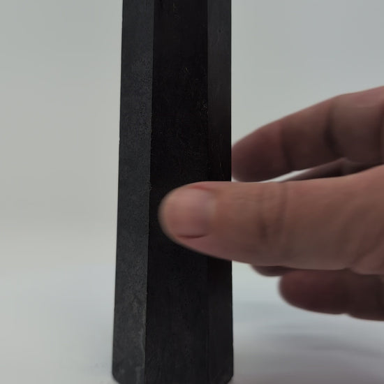Video of slim 300g Shungite tower from Karelia, highlighting its smooth polish and sleek vertical profile under soft light.