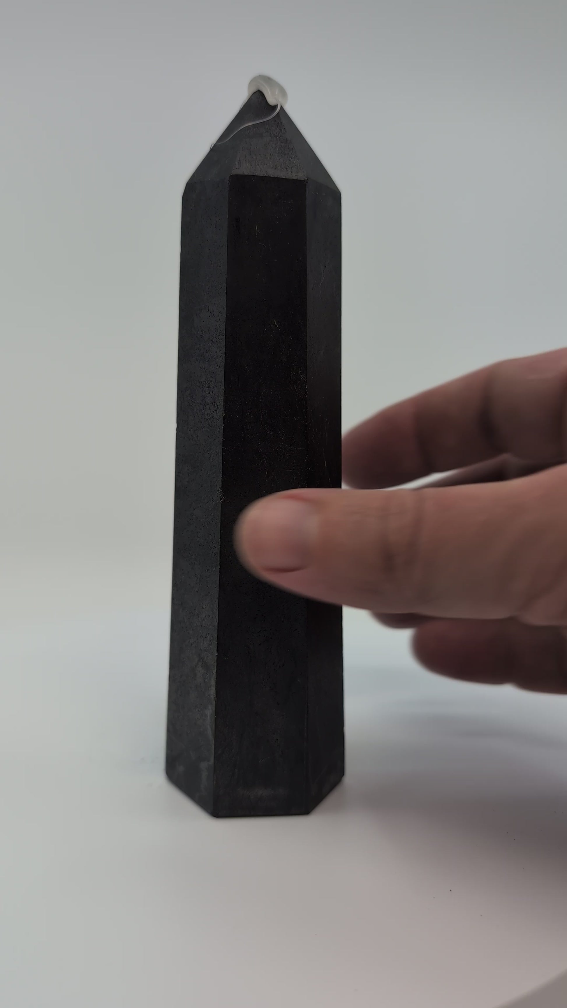 Video of slim 300g Shungite tower from Karelia, highlighting its smooth polish and sleek vertical profile under soft light.