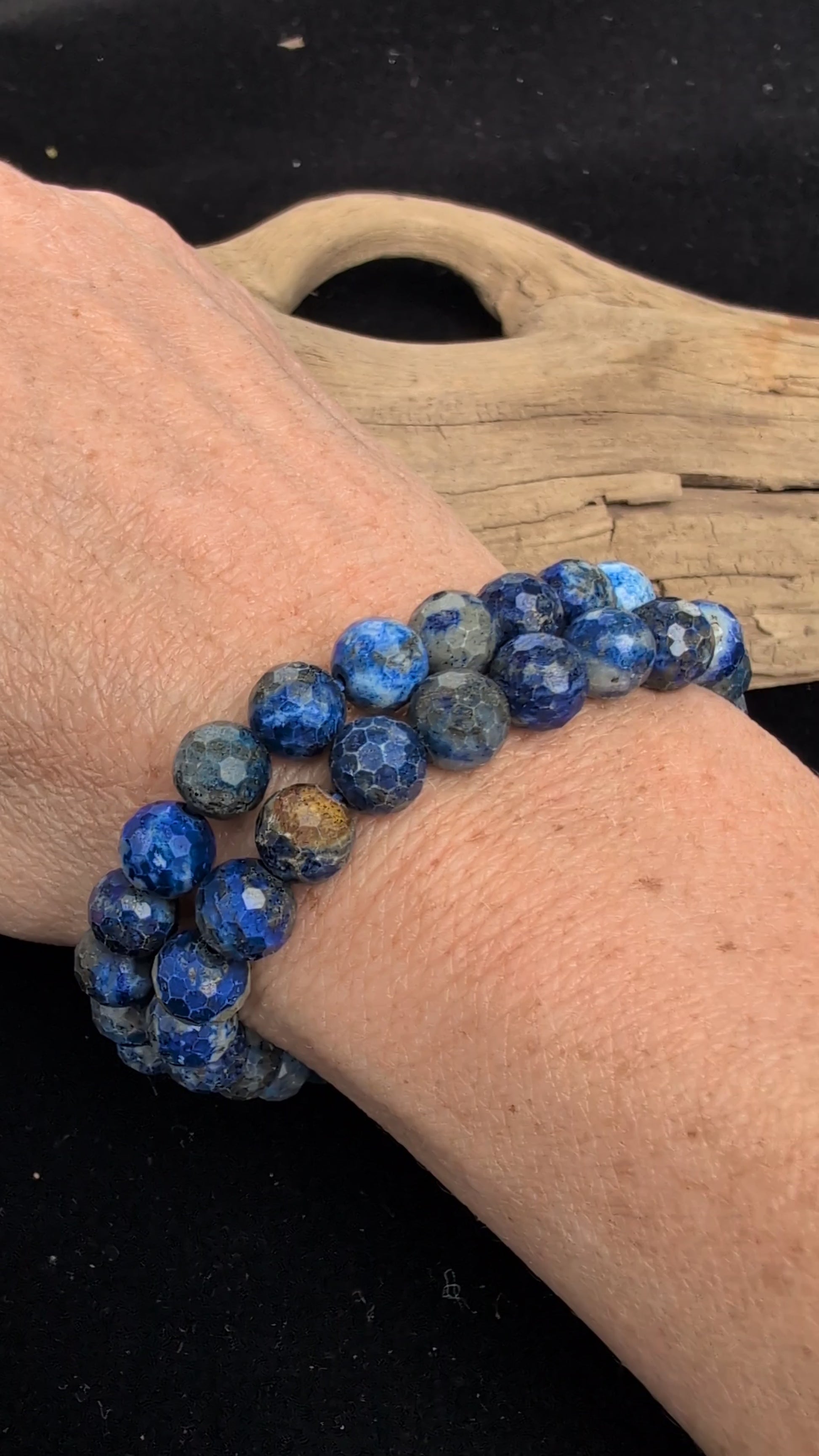 Video showcasing the highly reflective faceted texture, deep blue matrix, and flashing golden pyrite inclusions of an 8mm Lapis Lazuli beaded stretch bracelet worn on a wrist.