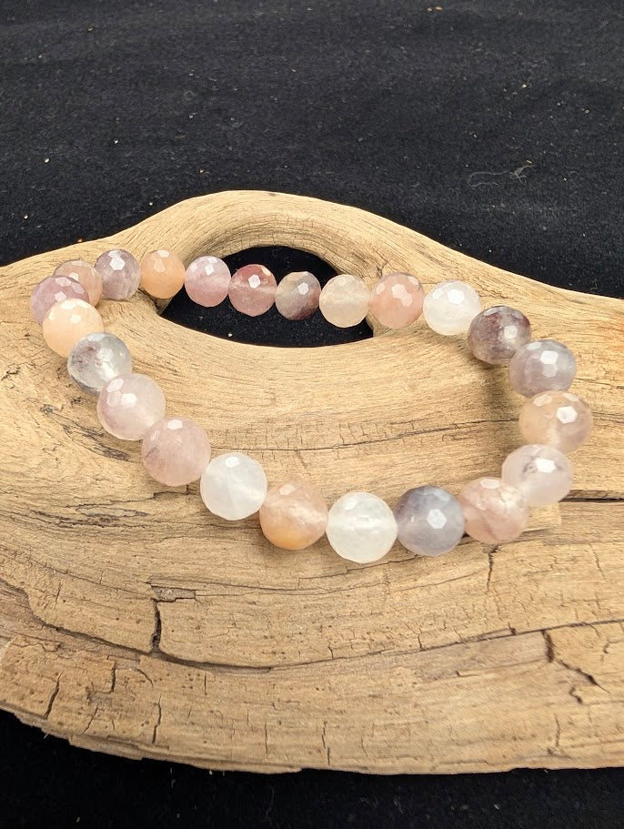 8mm faceted Purple Aventurine beaded stretch bracelet resting on a driftwood display, showing dusty mauve and pale lavender tones.