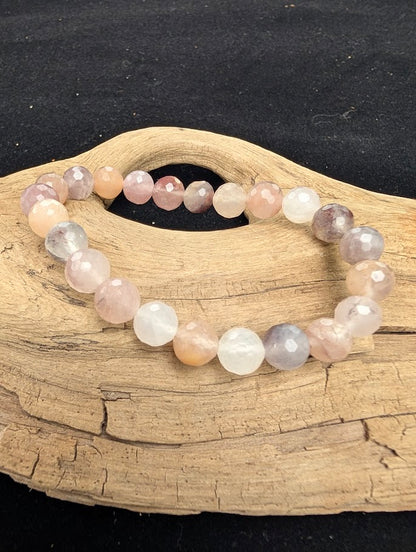 8mm faceted Purple Aventurine beaded stretch bracelet resting on a driftwood display, showing dusty mauve and pale lavender tones.
