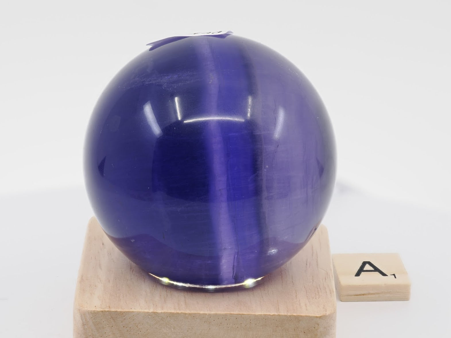 Vertical color banding and phantom growth zones in a 59mm Purple Fluorite sphere from Zhejiang.