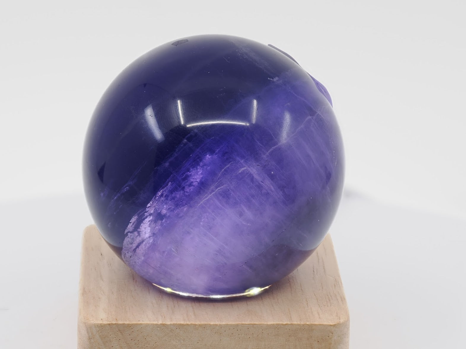 Internal view of 59mm Purple Fluorite sphere specimen A highlighting phantom layers and clarity.