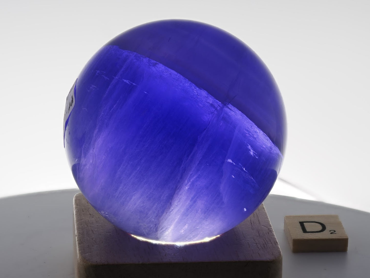 Intense neon-lilac glow and rising smoke phantom effects in a backlit 66mm Fluorite sphere.