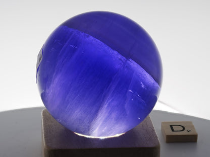 Intense neon-lilac glow and rising smoke phantom effects in a backlit 66mm Fluorite sphere.