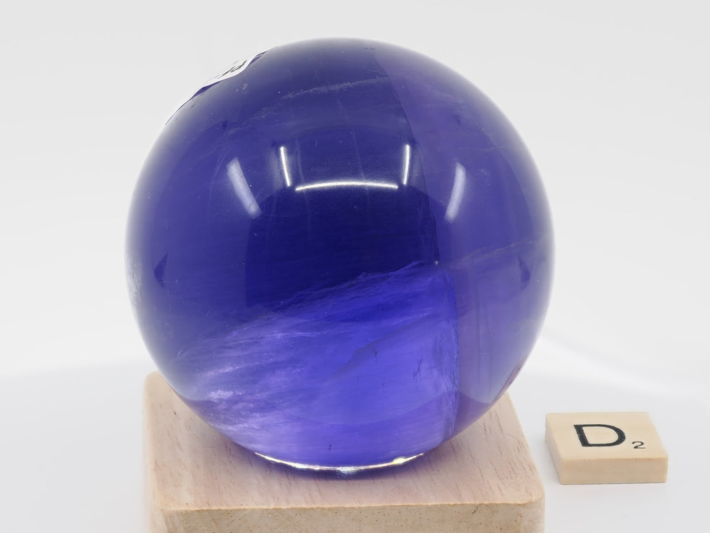 Glowing internal phantom structure of 66mm Purple Fluorite sphere specimen D under backlighting.