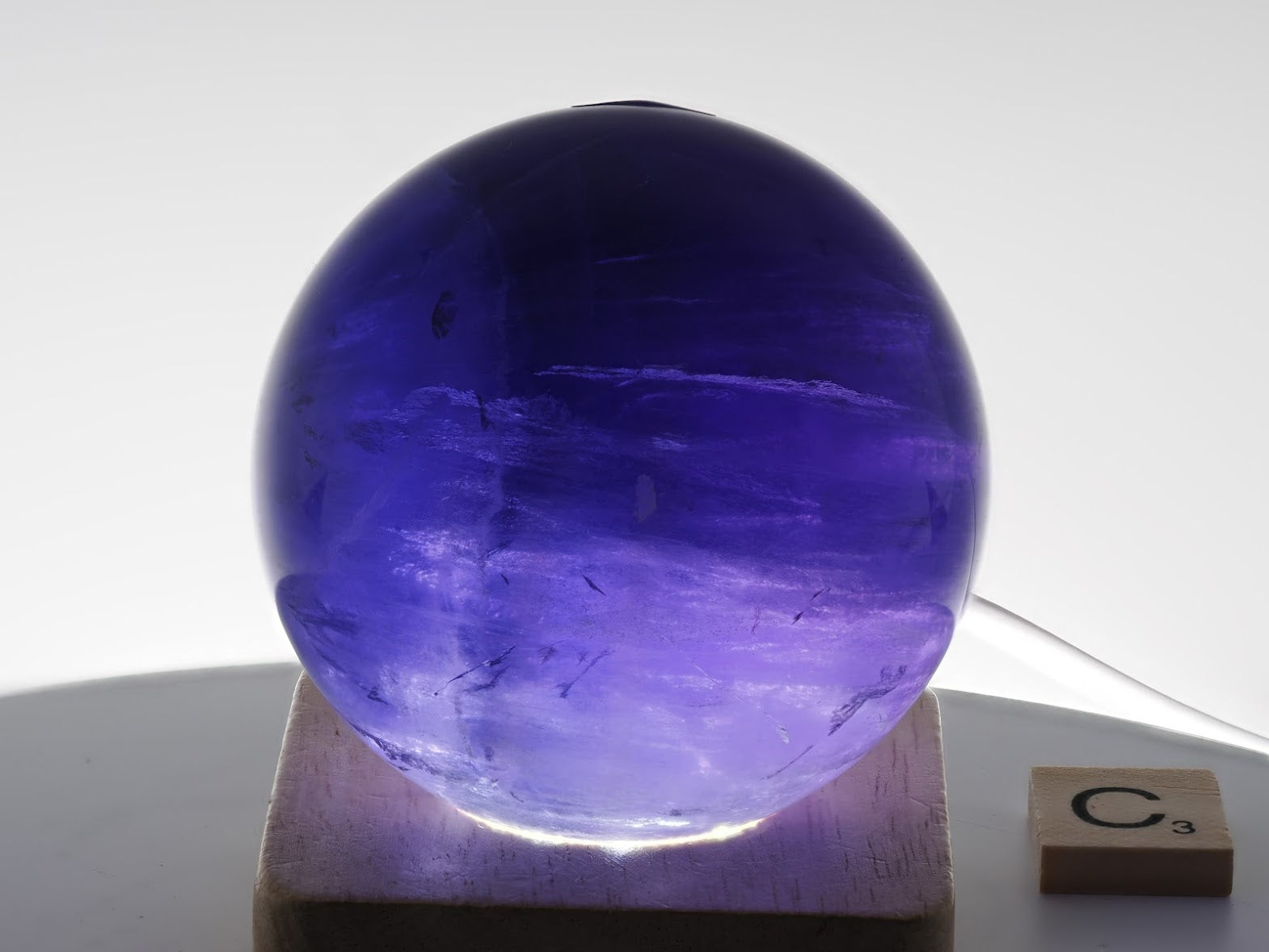 69mm phantom Purple Fluorite sphere illuminated to show watery clarity and growth layers.