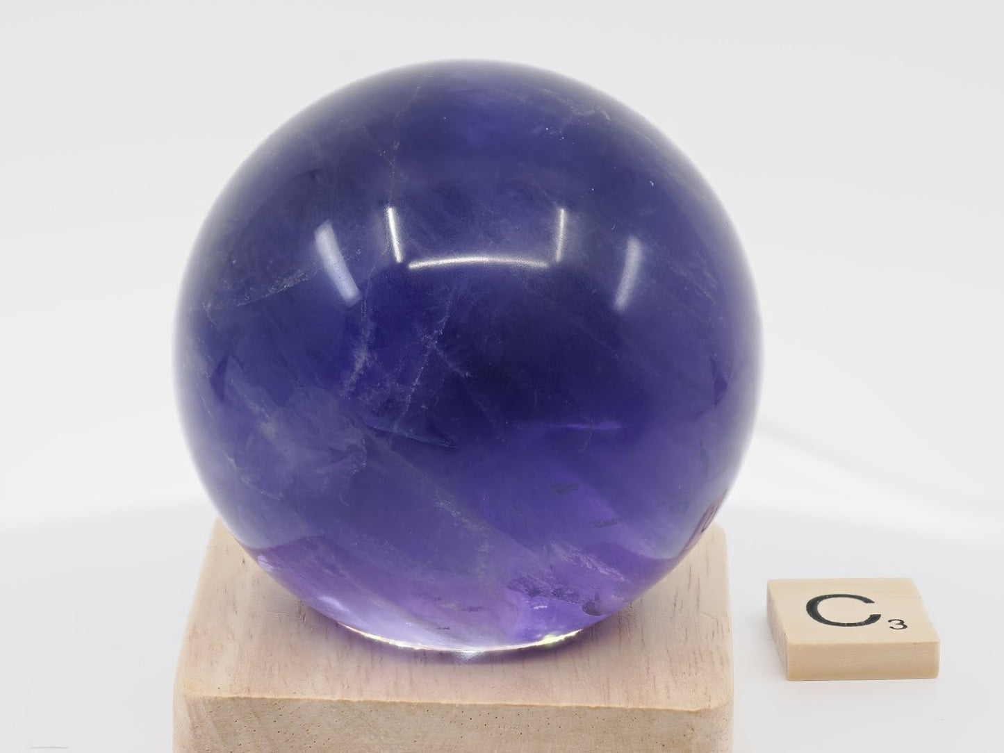 69mm Purple Fluorite sphere specimen C displaying exceptional internal clarity and "grape" saturation.