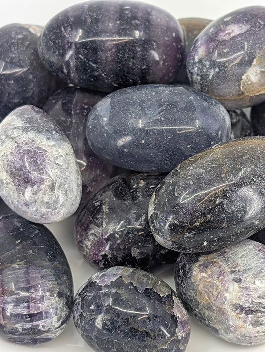 Close-up of Purple Fluorite tumbled stones showing color zoning