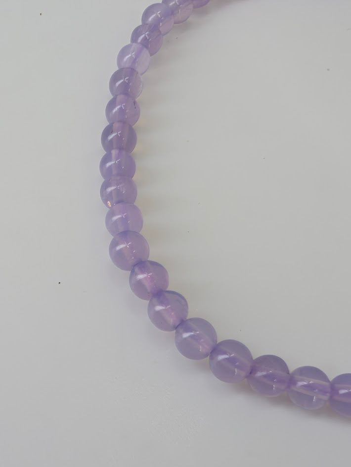 Detailed view of Purple Jade beads showing smooth surface and even color