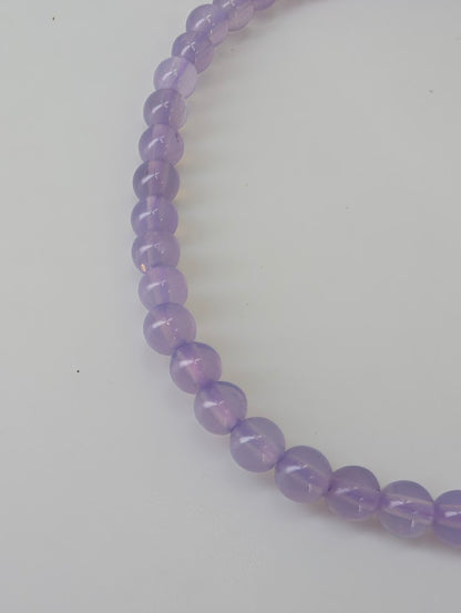 Detailed view of Purple Jade beads showing smooth surface and even color