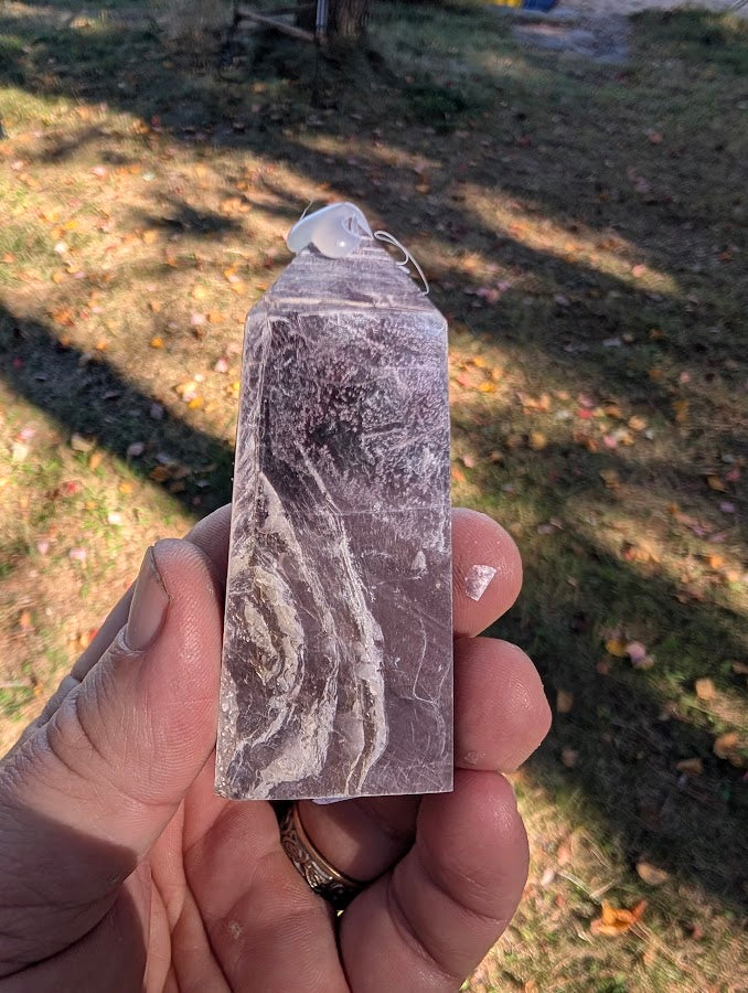Angled shot of Purple Lepidolite tower highlighting violet and silver reflections