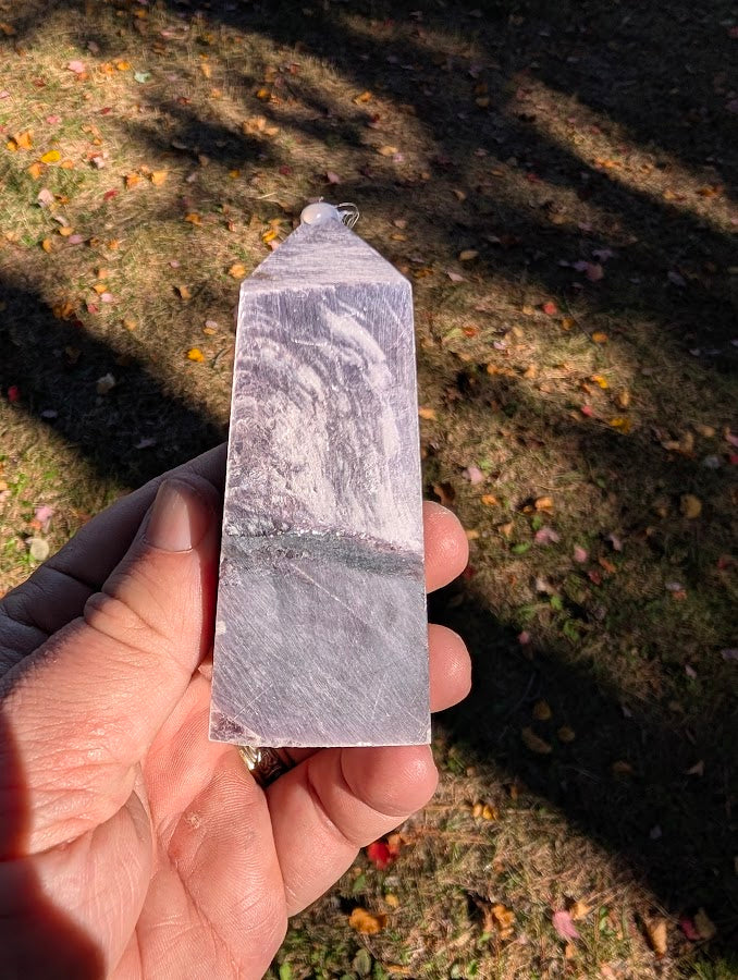 Angled shot highlighting silver reflections and broad display face on lepidolite tower