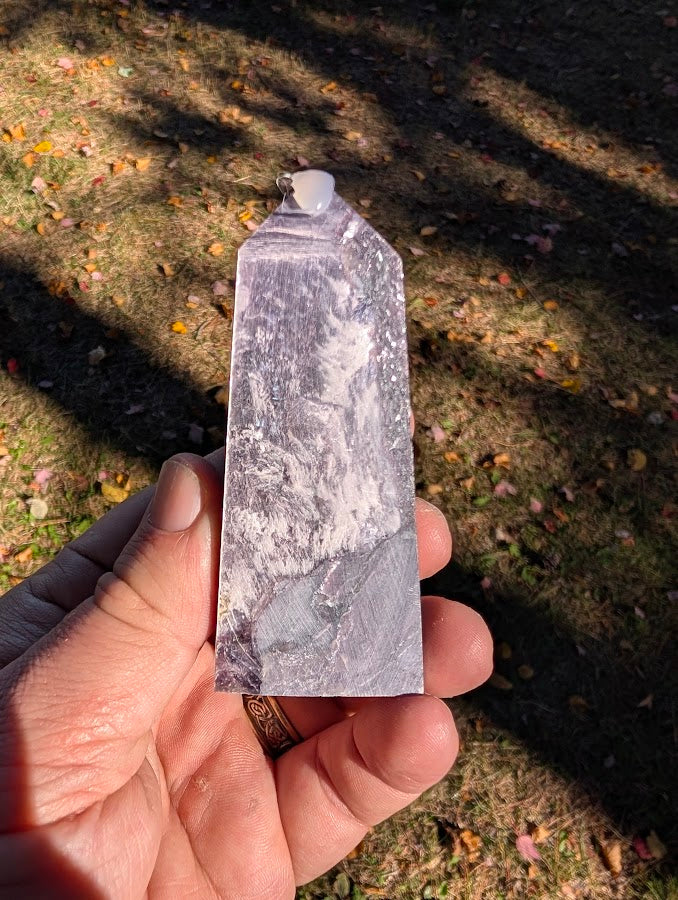 Close-up of polished Brazilian lepidolite showing sheeted texture and violet–silver sheen