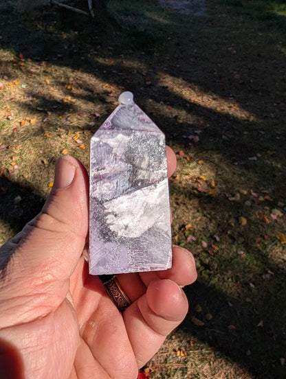 Angled shot highlighting silver reflections and broad display face on lepidolite tower