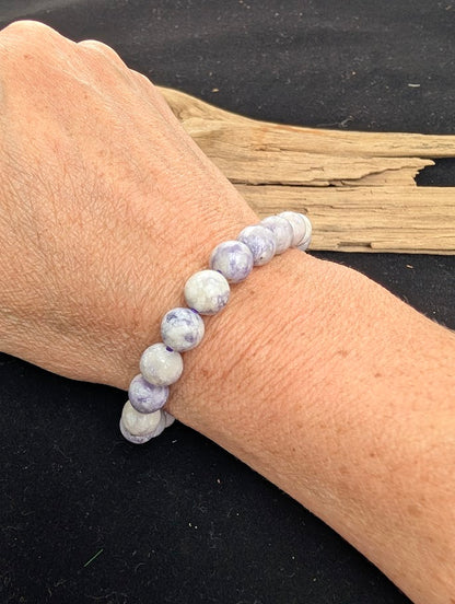 8mm polished Purple Opal beaded stretch bracelet worn on a wrist for size scale.