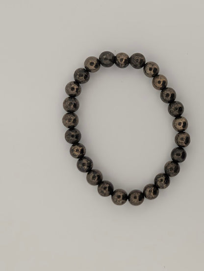 Top-down view of 8mm pyrite stretch bracelet on white background