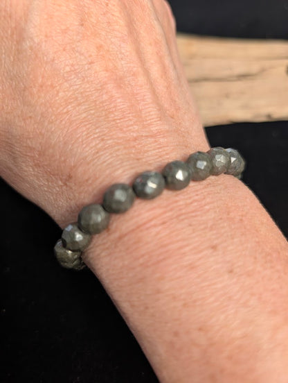 8mm faceted Pyrite beaded stretch bracelet worn on a wrist for size scale.