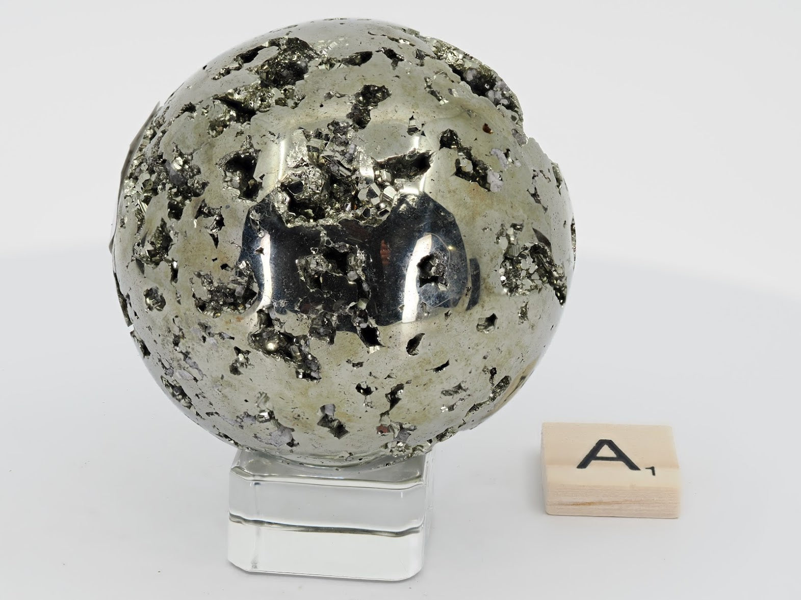Side view of Pyrite Sphere A highlighting smooth reflective surface and natural pits.