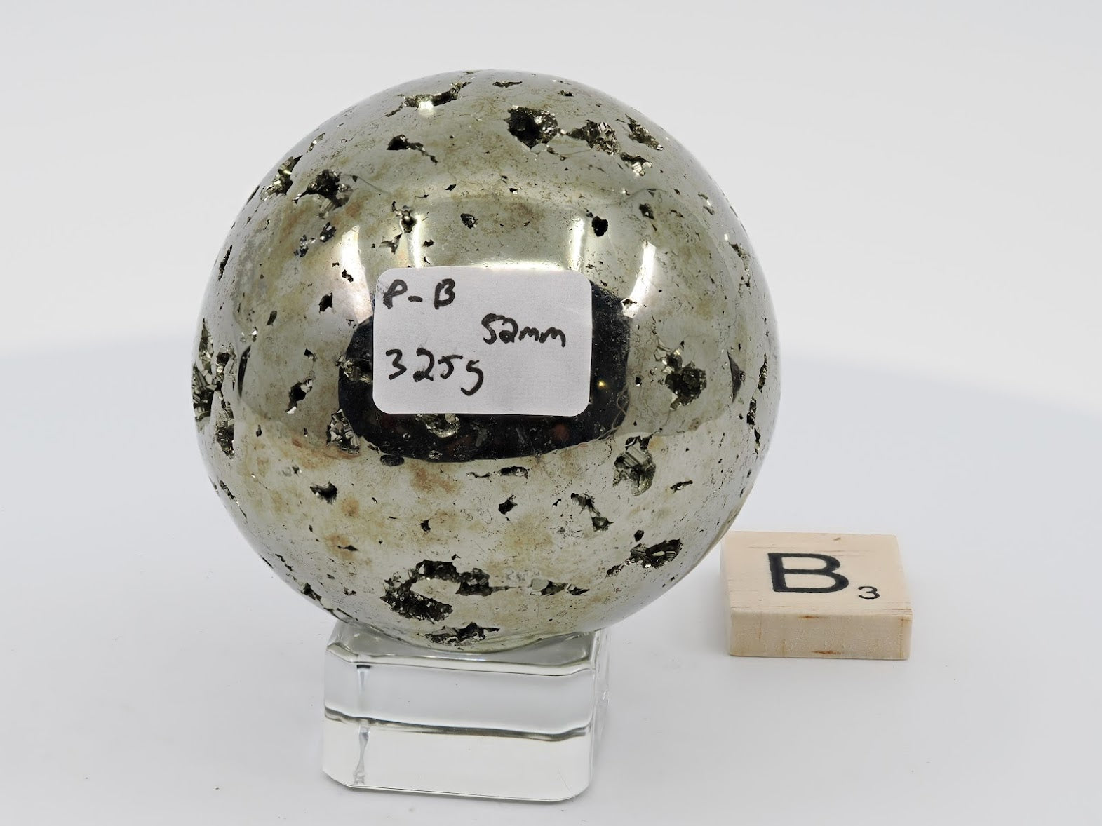 Peruvian Pyrite sphere Specimen B (325g) with scattered druzy pockets and label.