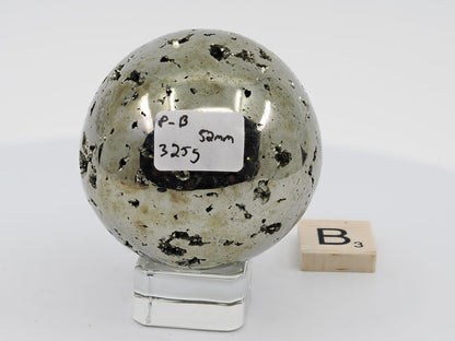 Peruvian Pyrite sphere Specimen B (325g) with scattered druzy pockets and label.