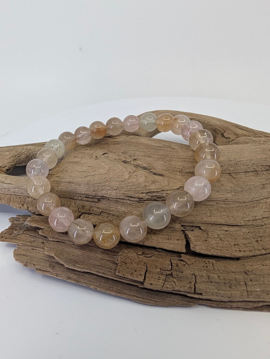 6.5mm Rabbit Hair Rutile Quartz bracelet in the 'Angora' light variant with champagne silk on driftwood.