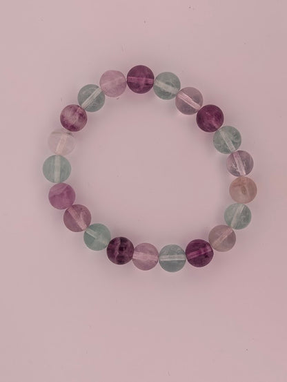 Top-down view of 8mm rainbow fluorite bracelet on white background