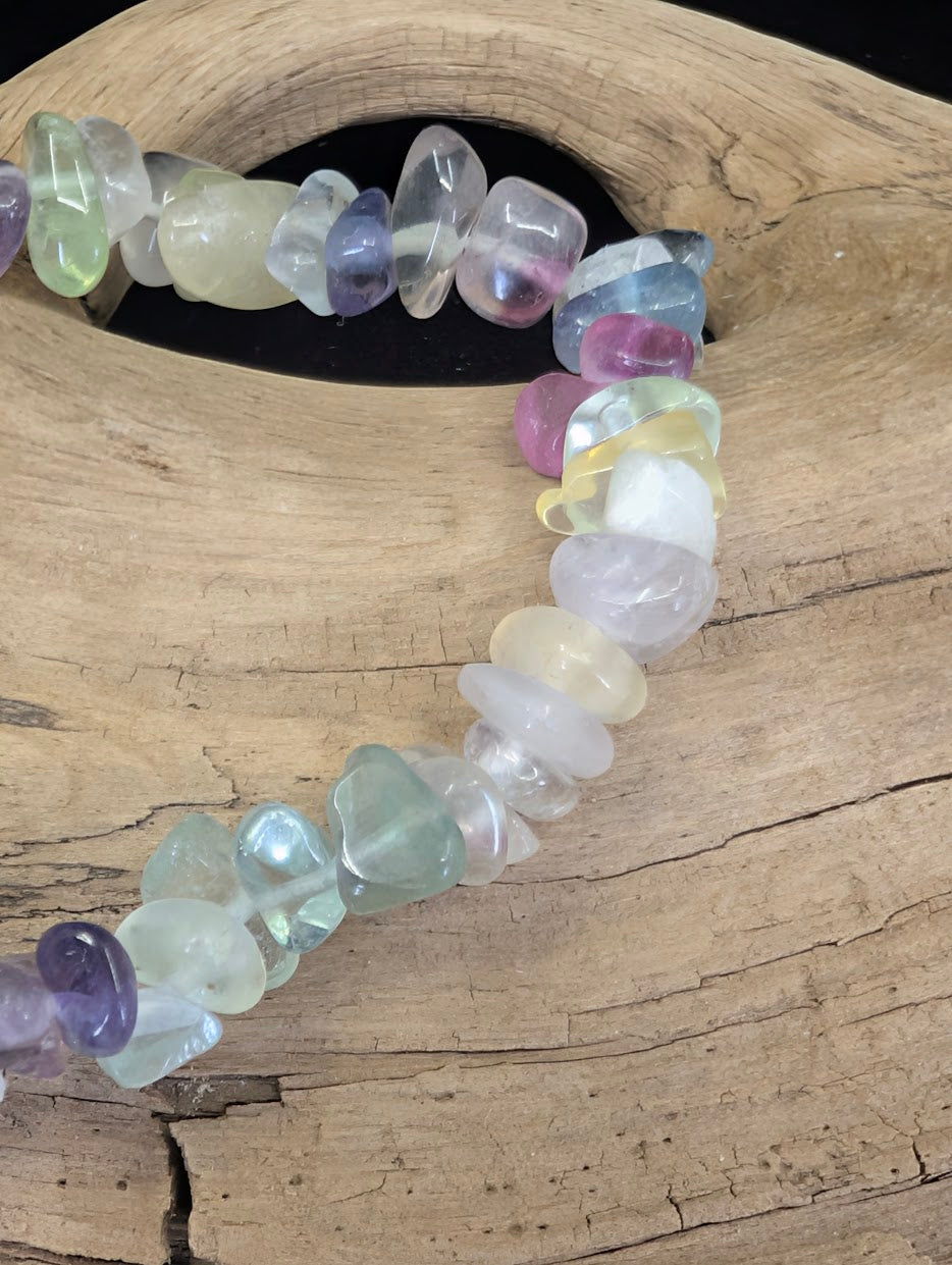 Close-up of polished Rainbow Fluorite chips, highlighting natural color zoning and the diverse range of gemmy purple and green hues.