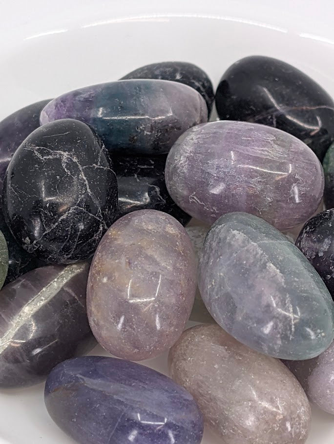 Close-up of Rainbow Fluorite tumbled stones showing banded color zones