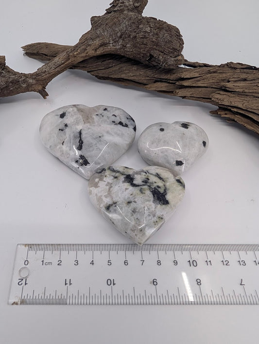 Comparison of Small, Medium, and Large Rainbow Moonstone hearts showing white matrix and black tourmaline inclusions.