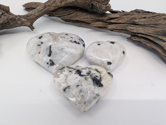 Comparison of Small, Medium, and Large Rainbow Moonstone hearts showing white matrix and black tourmaline inclusions.